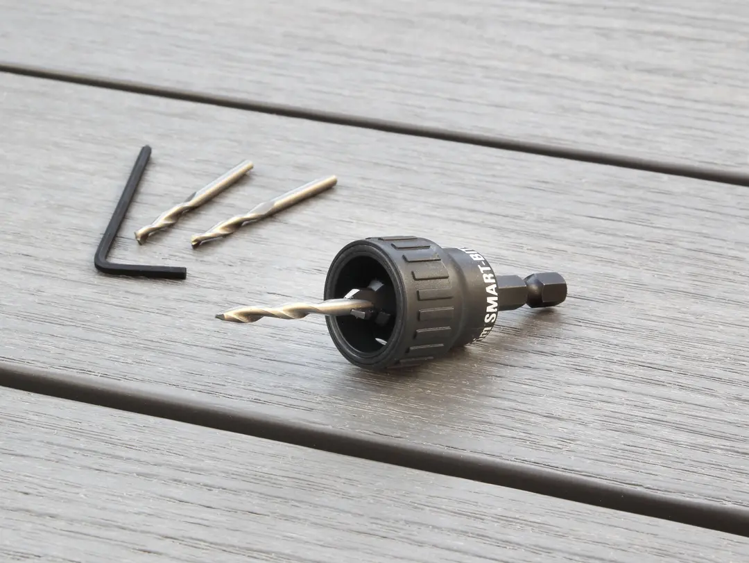 Cobra® Smart-bit 8G, deux forets de rechange et une clé hexagonale posés sur du bois ; toutes pièces en métal.