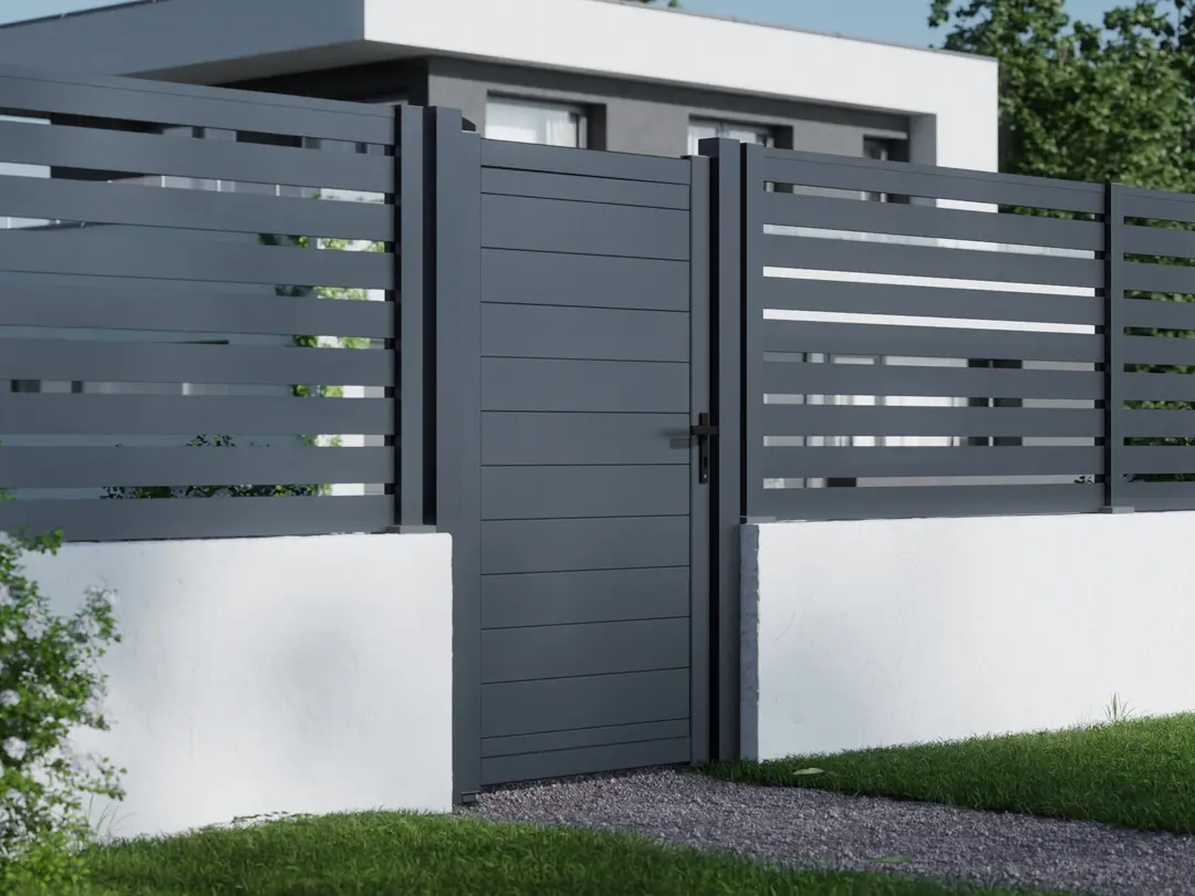 BOSTON - Poteau aluminium 90x90x2750mm avec chapeau, gris, installé avec portail et clôture à lames horizontales sur base en béton blanc.