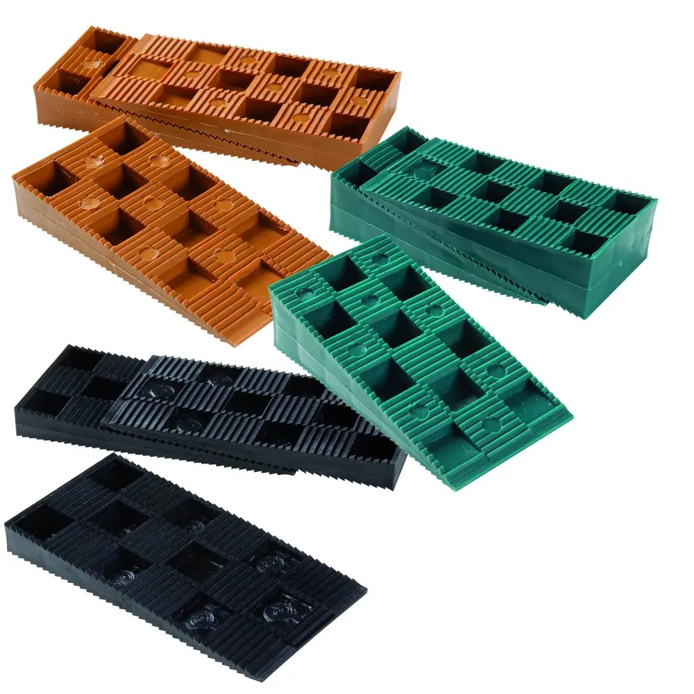 Cales plastiques rectangulaires marron, vertes et noires avec motif en grille, posées sur fond blanc. Référence ou marque non lisible.